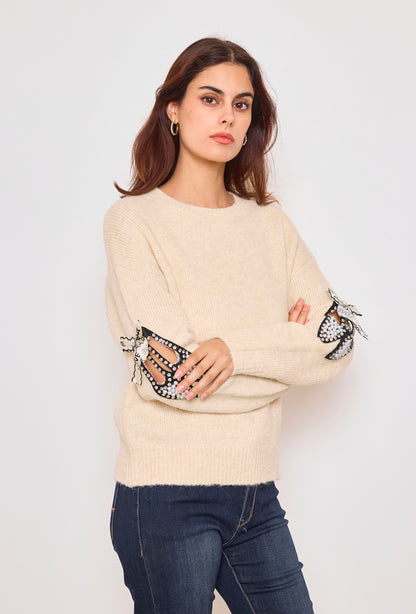 Sweater with ribbons and rhinestones on the sleeves