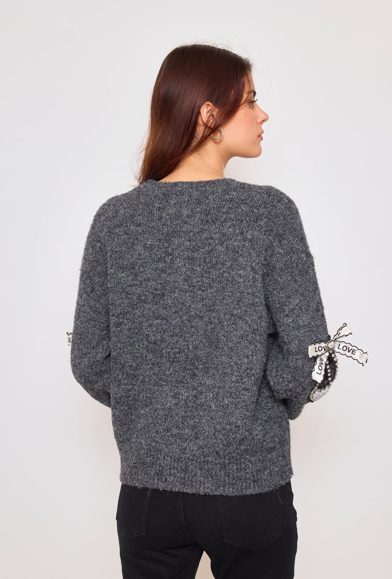 Sweater with ribbons and rhinestones on the sleeves