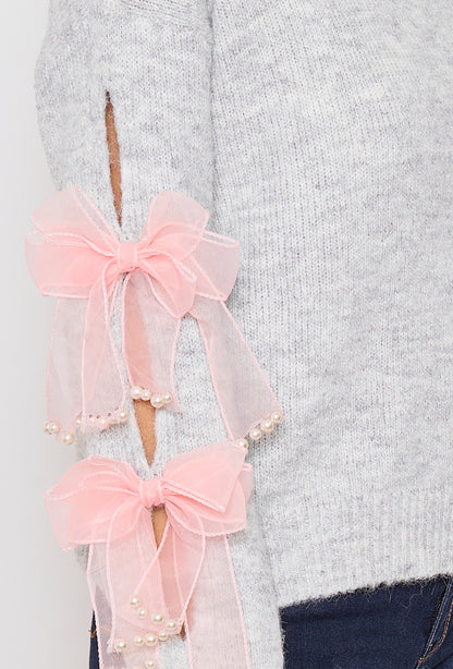 Sweater with ribbons and rhinestones on the sleeves